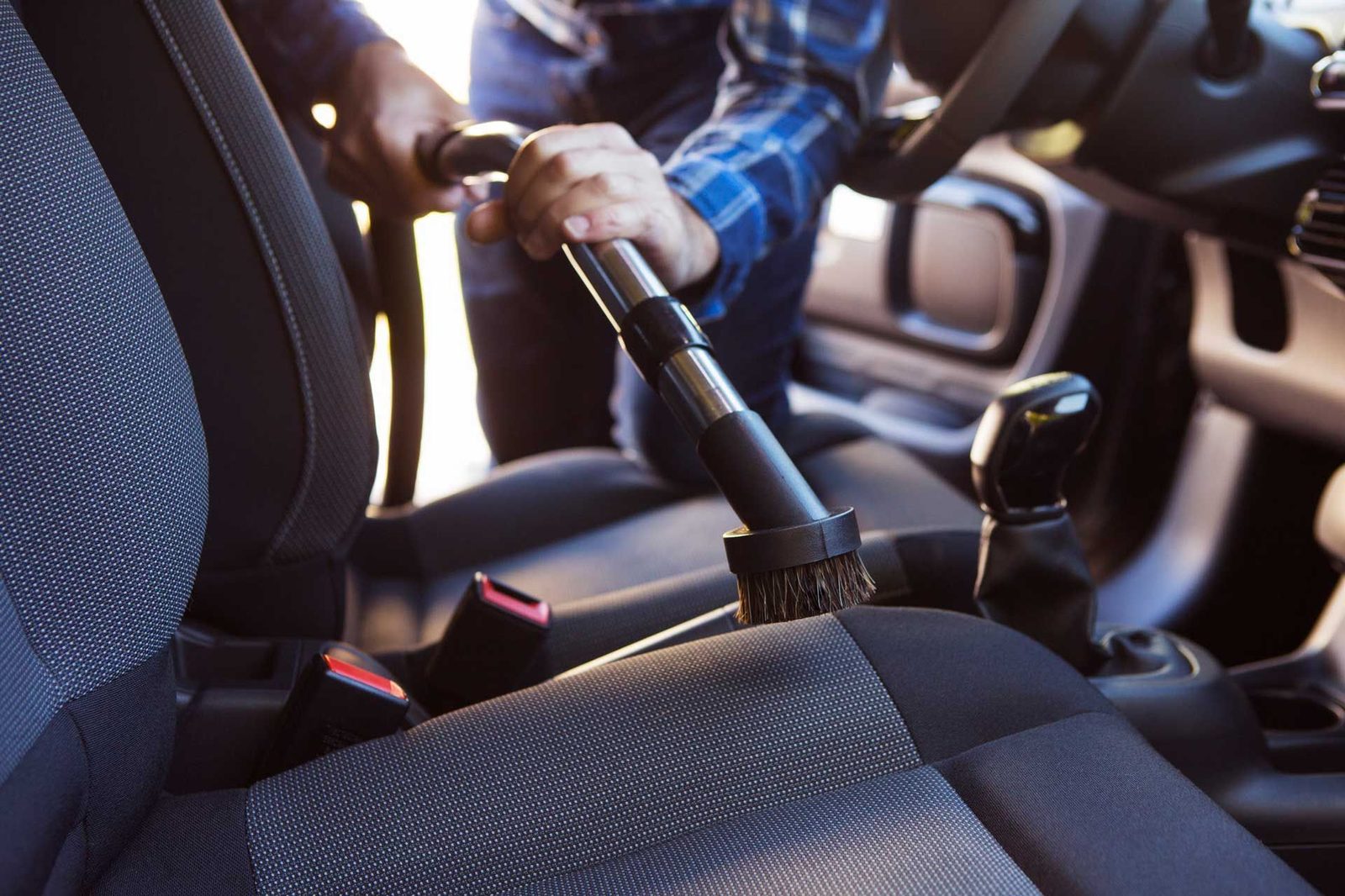 Vehicle interior being vacuumed as part of an odor control treatment